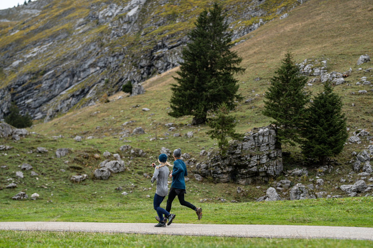 Two people running along a valley path