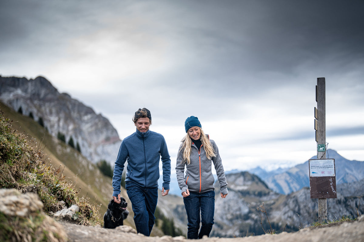 A couple hiking in the mountains with a dog